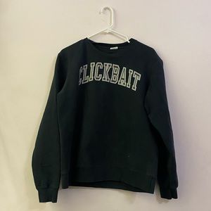 black crewneck, lettering “clickbait”